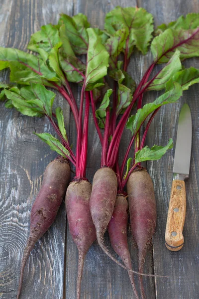 Bir ahşap yüzeyde bir bıçakla taze organik kırmızı pancar