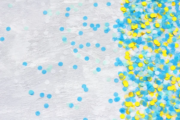 Colorful confetti on light gray background, top view, horizontal
