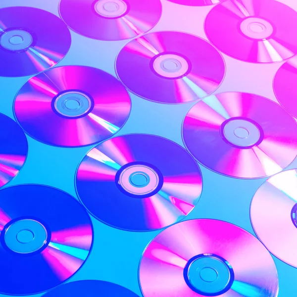 CDs on a plain background illuminated with neon light pink blue, Concept of night club life ,minimal style