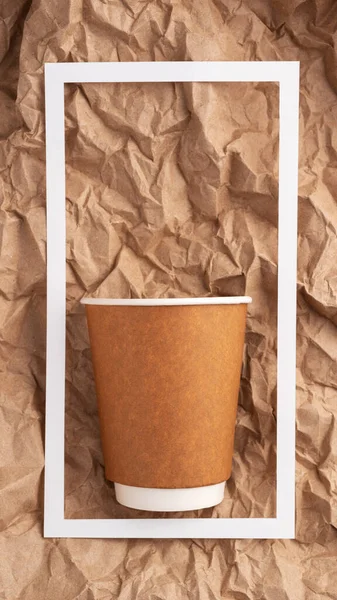 Kraft paper background ,cardboard coffee Cup,white paper frame, recycled material, recycled cellulose