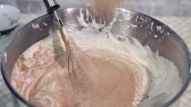 Sıradan bir bayram için sünger keki hazırlamak, malzemeleri karıştırmak.