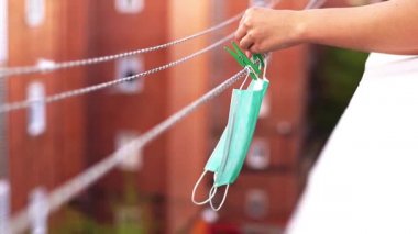 Cerrahi maskeler karantina sırasında tekrar kullanılması için cımbızla birlikte çamaşır ipine asıldı. Maske konseptini yeniden kullan.