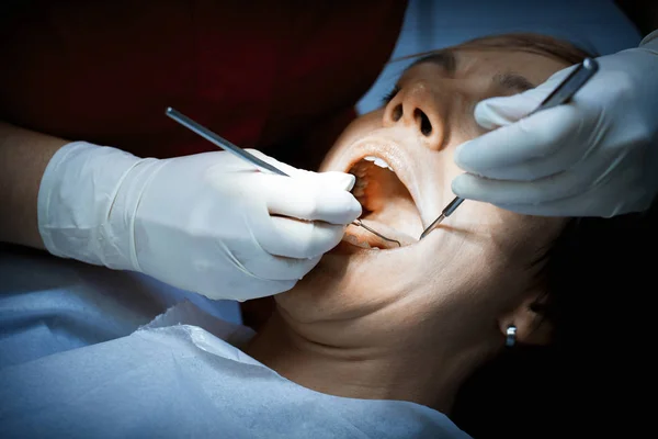 Dentista examinando um paciente dentes antes da cirurgia oral no de — Fotografia de Stock