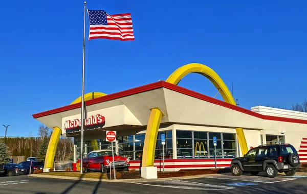 McDonald 's fast food restoranından geçiyor, Amerikan bayrağı sallanıyor.