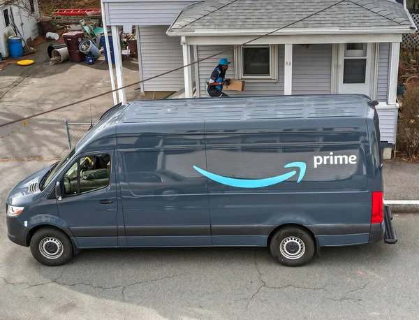 Amazon Prime teslimat kamyonu sürücüsü eve paket getiriyor.