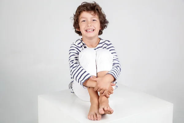 Lindo y divertido niño en camisa de rayas y jeans blancos —  Fotos de Stock