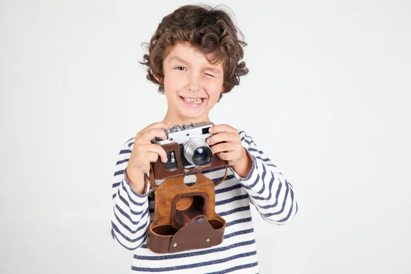 Lindo y divertido niño con cámara de película vieja sobre fondo blanco —  Fotos de Stock