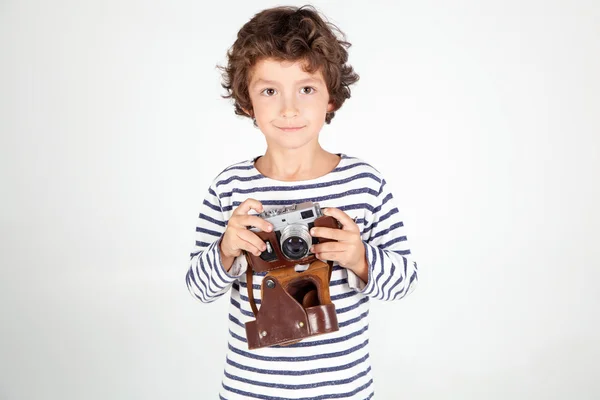 Alegre niño sonriente (niño) sosteniendo una cámara de cine sobre blanco b —  Fotos de Stock