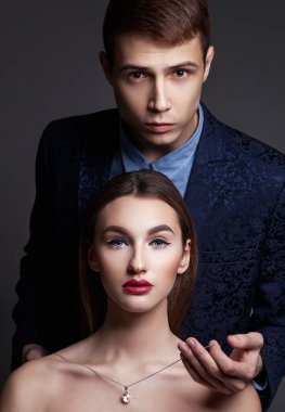 Glamour moda çift. Delikanlı adam bir perl kolye üzerinde koyar