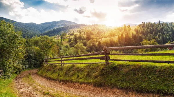 Schöne Sommerlandschaft mit Holzzaun und Bergen. blau — Stockfoto