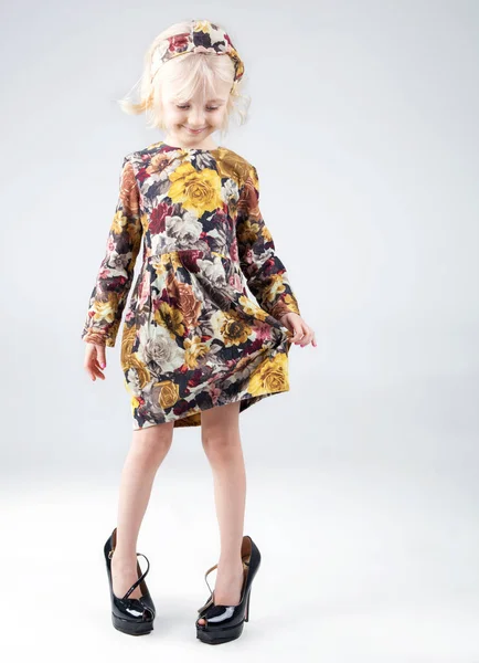Słodkie i zabawne moda mały dziewczyna pozuje w buty matki z h — Zdjęcie stockowe