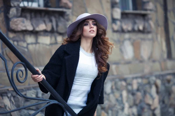 Mooie elegante vrouw in stijlvol trendy zwarte jas en hoed ove — Stockfoto