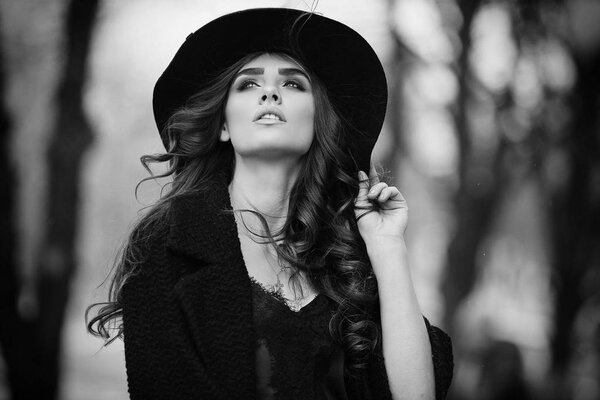 Beautiful elegant woman in black hat outdoor. Fashion look, european style.
