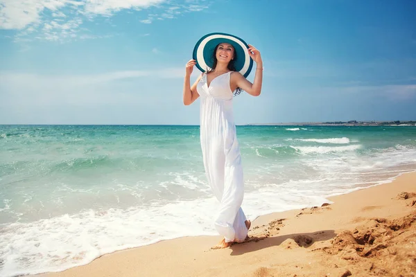 긴 하얀 드레스를 입고 해변에 산책 하는 아름 다운 젊은 여자는 — 스톡 사진
