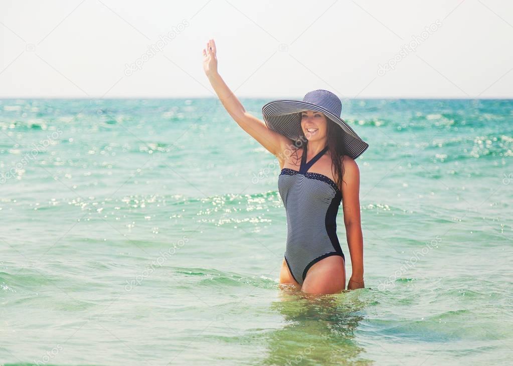 Beautifil young woman about 30 years old in stripe swimsuit and 