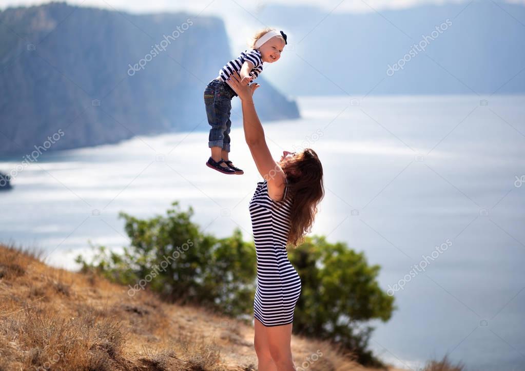 Happy beautiful mother and her daughter enjoing wondeful landsca