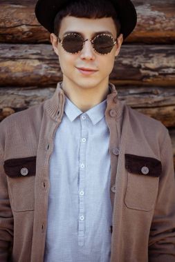 Atractive yenilikçi genç adam güneş gözlüğü, şapka ve rahat kıyafet o