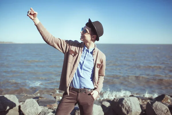 Joven moda metrosesual hipster hombre haciendo selfie en el mar . —  Fotos de Stock