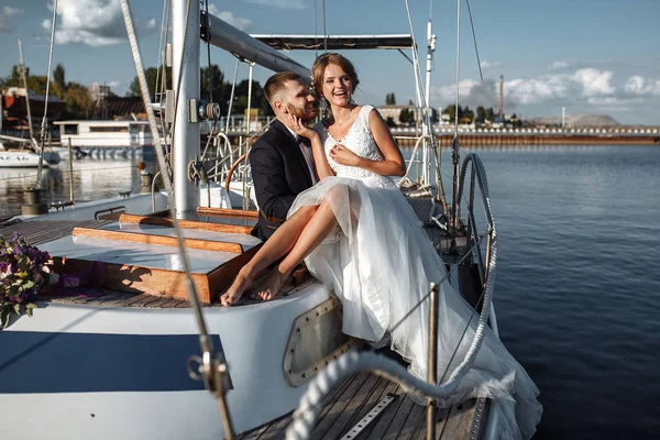 Wedding couple is hugging on a yacht. Beauty bride with groom. B