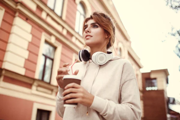 Autumn fashion concept. Young beautiful woman walking with coffe