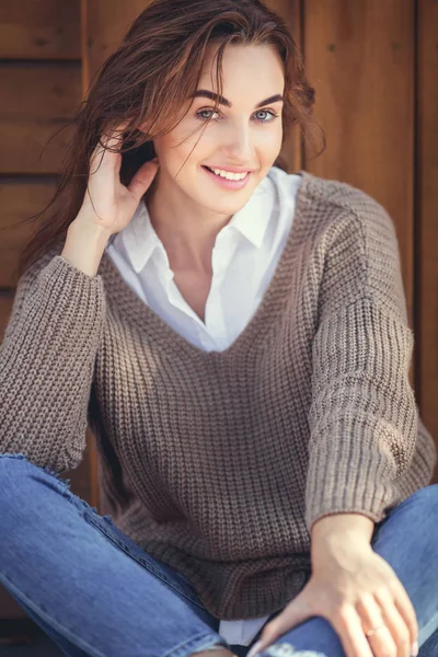 Casual kot pantolon ve yün kazak oturan genç güzel kadın