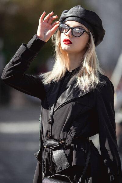 Модница в черной кожаной шапке, триумфальных очках и красных губах
.