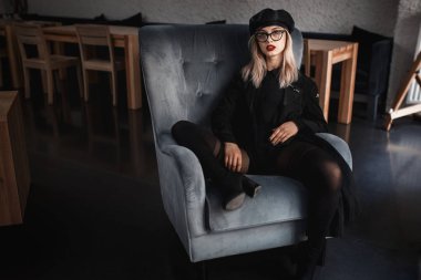 Kışkırtıcı poz kol sandalyede oturan genç seksi kadın. F