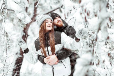 Birbirine aşık genç bir çift kış kar ormanlarında eğleniyor. Kazan.