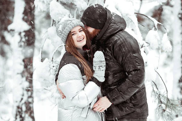 Feliz casal jovem apaixonado se divertindo na floresta de neve de inverno. Ganhar — Fotografia de Stock