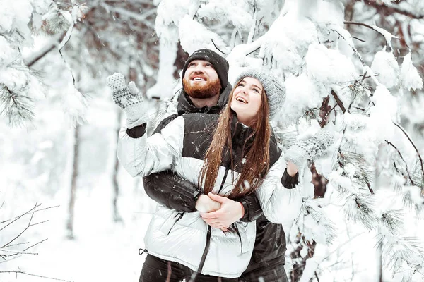 Feliz casal jovem apaixonado se divertindo na floresta de neve de inverno. Ganhar — Fotografia de Stock