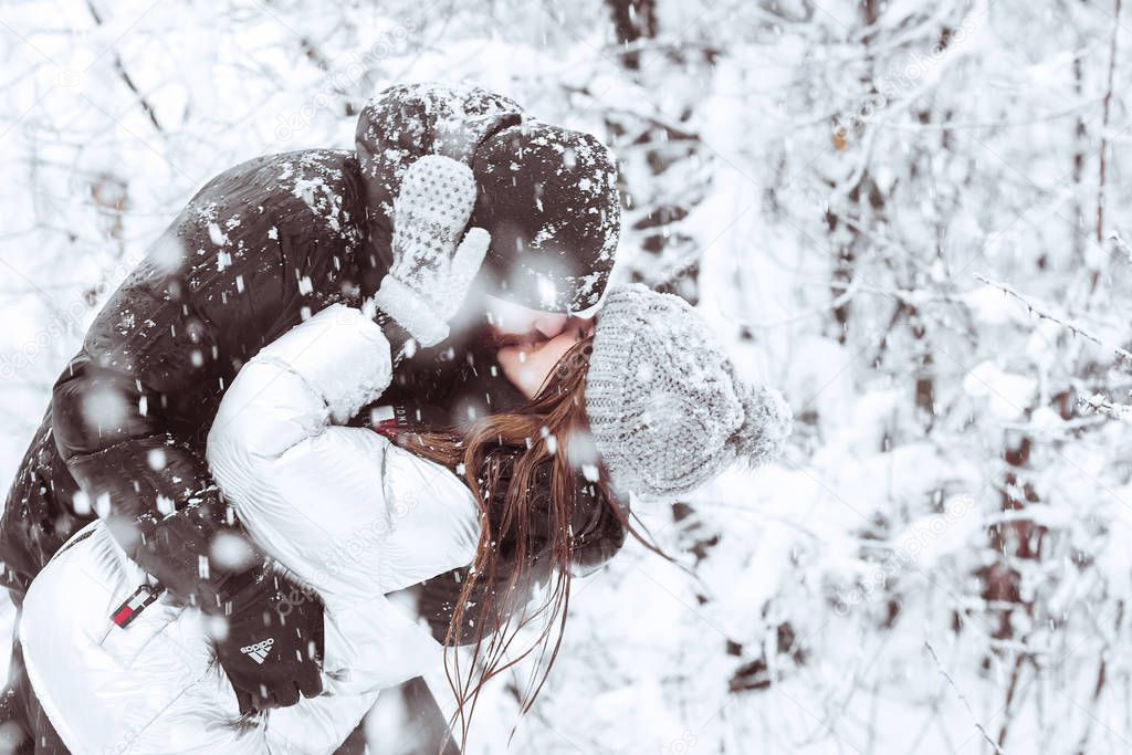 Happy winter holidays. Romantic young couple. Snowy winter day. 