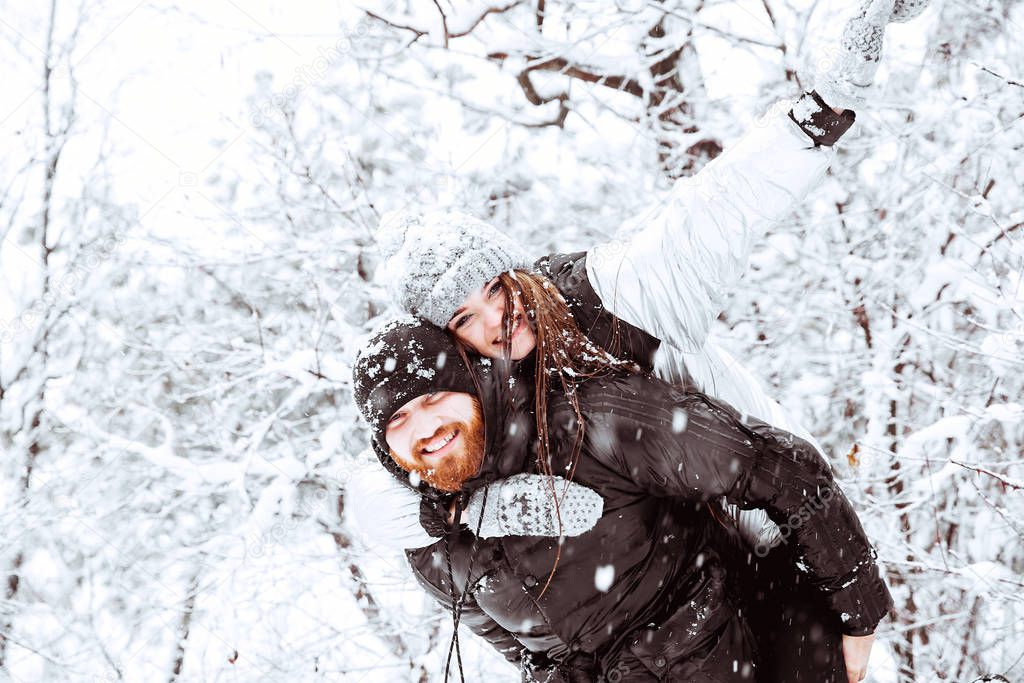 Happy winter holidays. Romantic young couple. Snowy winter day. 