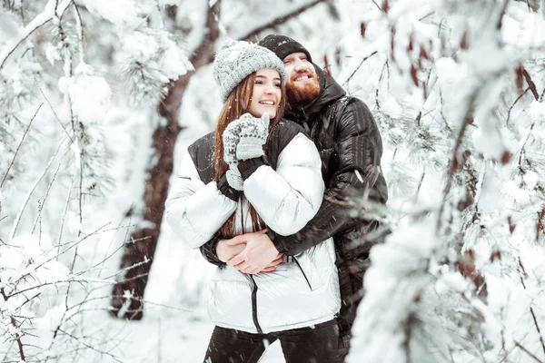 Feliz jovem casal apaixonado se divertindo na floresta de neve de inverno . — Fotografia de Stock