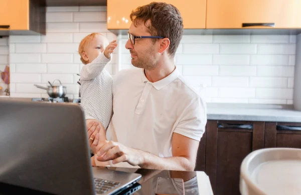 Joven Guapo Trabajando Casa Con Portátil Con Bebé Sus Manos — Foto de Stock