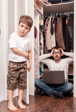 Baba, dizüstü bilgisayarda çalışmak için çocuklardan saklanmak için gardıropta sessiz bir yer bulmaya çalışıyor. Evden çalışıyorum. Merkez ofis. Karantinaya alın. Serbest Çalışan.