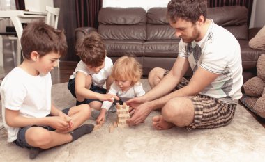 Mutlu aile kavramı. Baba evde kalıp çocuklarla oynuyor. Ailecek tatildeyiz, eğleniyoruz..