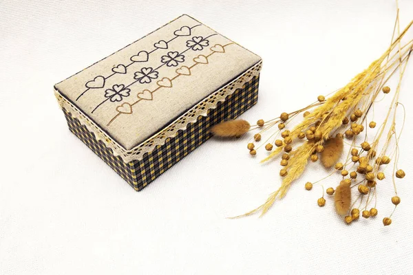  Beyaz arka planda eski bir kutu ve kuru çimenler