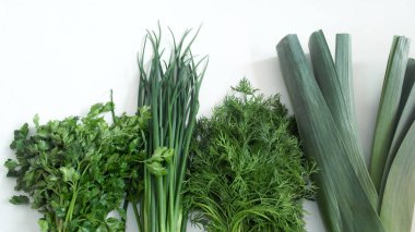 Beyaz arka planda salata, soğan ve maydanoz.