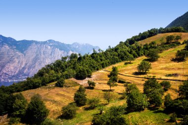Monte Baldo dağı İtalya 'daki Garda Gölü kıyısındaki Malcesine tatil beldesinin arkasındadır. Dağın tepesine bir teleferik ulaşır ve tepesinde Alpaca ve koyunlarla birlikte dağlık çayırlar ve bir hediyelik eşya dükkanı vardır. Paragliderler rüzgarı yakalayıp aşağı atlarlar.