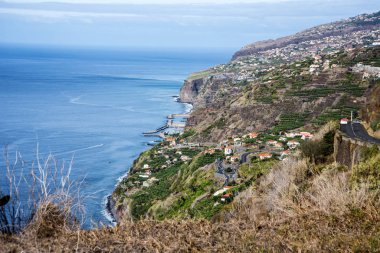 Madeira is a very mountainous Island with steep cliffs falling into the Atlantic Ocean.Mists roll over and through the Mountains.The roads are steep and tortuous with many tunnels Everywhere there are flowers and terraces or levadas growing crops