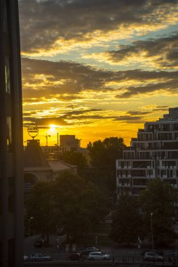 Almanya 'nın Berlin şehrinin üzerindeki Batan Güneş akşam gökyüzünü aydınlatıyor.