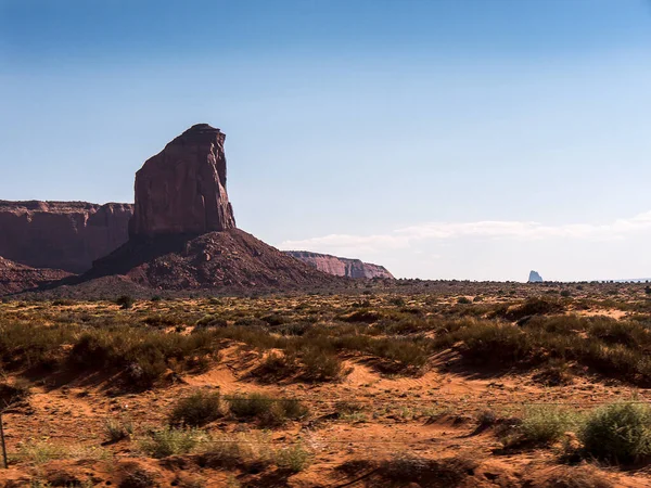 纪念碑谷提供了也许是美国西部最持久和决定性的形象 孤立的红色中间点和扣子被空旷的 沙质的沙漠包围着 那是纳瓦霍部落的土地 — 图库照片