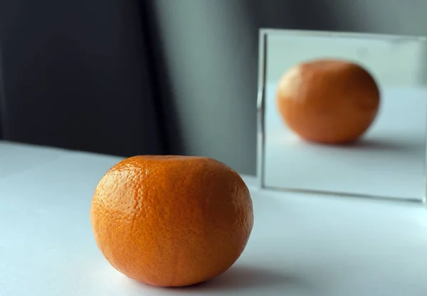 Laranja Está Refletindo Espelho Quadrado Superfície Branca Com Fundo Cinza — Fotografia de Stock