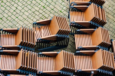 Bir restoranın terasında bir yığın sandalye. COVID-19 pandemisi yüzünden burada ziyaretçi yok. Kapalı.. 