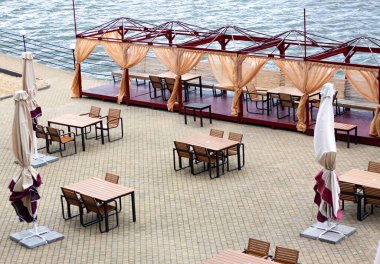 Baharda nehrin kıyısında boş bir restoran terası. COVID-19 pandemisi yüzünden burada ziyaretçi yok. Kapalı.. 