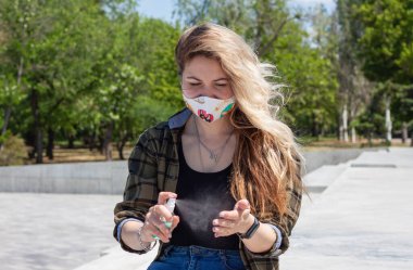 Beyaz koruyucu maskeli, balıklı sarışın kız mavi dezenfektan kısırlaştırıyor.. 