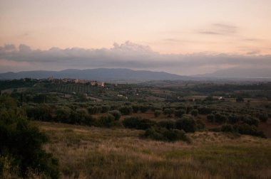 Günbatımında sıcak renklerle İtalya 'da Toskana manzarası