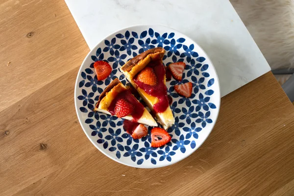 Renkli tabakta taze çilek ve çilek soslu cheesecake. Tatlı nefis..