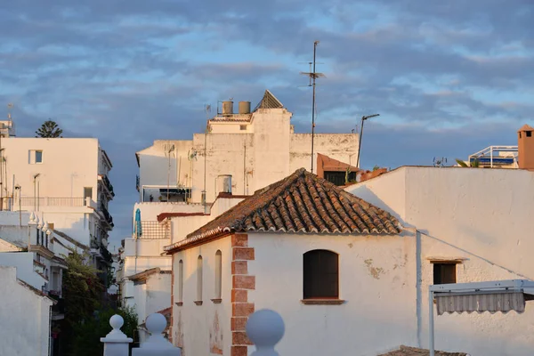 White spanish houses in old town of Andalusia with roof tiles in sunset.