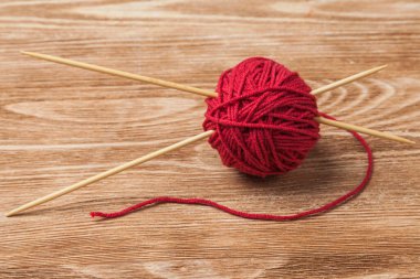 İki örgü iğnesiyle kırmızı iplik yumağı